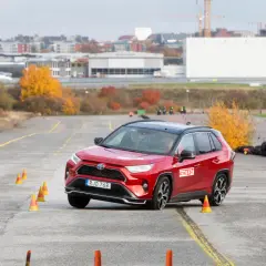 Röd Toyota RAV4 Hybrid genomför ett test på en bana med koner. En bil som testas för att se om det finns något toyota rav4 hybrid problem.