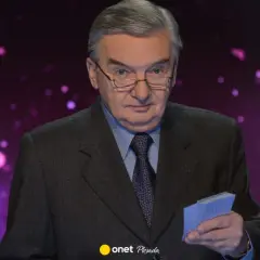 Tadeusz Sznuk w garniturze, z okularami na nosie, trzyma w dłoni małe niebieskie karty. Może to być nawiązanie do jego żony, która kiedyś grała w karty.