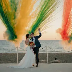 Para młoda całująca się na tle kolorowych fajerwerków na plaży.