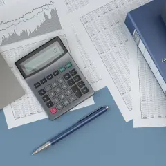 Biurko z laptopem, kalkulatorem i dokumentami. Przygotowanie odpis na zfśs 2026.