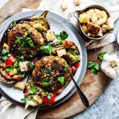 Ugnsbakad aubergine fylld med köttfärs, tomater och krutonger, toppad med färsk persilja. En härlig aubergine i ugn.