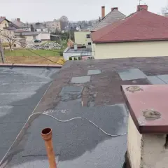Dach płaski z papą, przygotowany do ocieplenia nakrokwiowego. Widoczny komin i rynna.