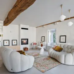 Salon cosy avec cheminée et canapés arrondis. La ventilation appartement est discrète, intégrée au design moderne.