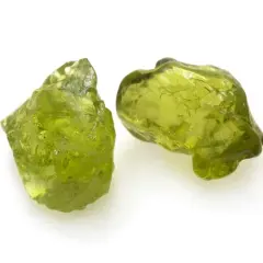 Zwei rohe Peridot-Kristalle in leuchtendem Grün. Ihre natürliche **Peridot Wirkung** soll angeblich das Herz öffnen und positive Energie fördern.