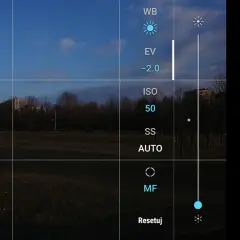 Aparat w telefonie z widokiem na park. Na ekranie opcje: WB, EV, ISO 50, SS AUTO, MF. Jak ustawić długi czas naświetlania w telefonie?