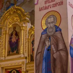 Ikona świętego z brodą i aureolą, obok niej postać kobieca. W tle złota ikona Matki Boskiej z Dzieciątkiem. Motyw sztuki sakralnej.
