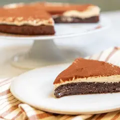 En saftig kladdkaka med en krämig topping, pudrad med kakao. Perfekt för fikat!
