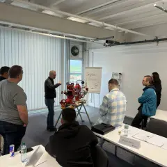 Männer nehmen an einer Schulung teil, bei der ein Sprinklerwart die Funktionsweise eines Sprinklersystems erklärt.