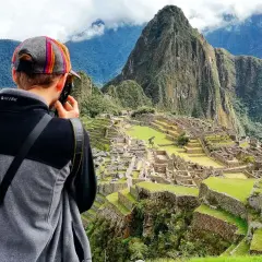 Turysta robi zdjęcie Machu Picchu. To idealne miejsce, by sprawdzić, kiedy najlepiej lecieć do Peru, by podziwiać te cuda.