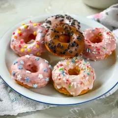 Sechs bunte Donuts, die Lust aufs **Donuts selber machen** machen: Rosa mit Sternen, pink mit bunten Streuseln, braun mit Schokostreuseln und weitere.
