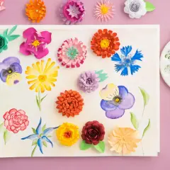 Kolorowe kwiaty z papieru i akwarele na kartce, idealne na prezenty na Dzień Mamy DIY. Pędzel i paleta malarska obok.