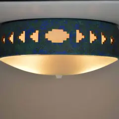 Lámpara techo azul turquesa con diseño geométrico calado, emite una luz cálida y acogedora.