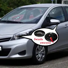 Srebrny Toyota Yaris z zaznaczonymi światłami awaryjnymi. Pod maską kryje się silnik, ale to kontrolki na desce rozdzielczej informują o problemach.