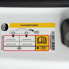 Naklejka z informacją o ciśnieniu w oponach. Tabela zawiera rozmiar opon 255/40ZR19 96Y i zalecane ciśnienie 220 KPA, 32 PSI.