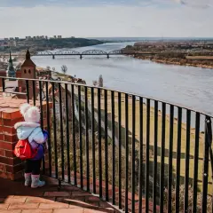 Dziecko z plecaczkiem podziwia panoramę Grudziądza i Wisły. Widok na mosty i miasto to jedne z głównych atrakcji.