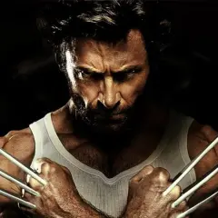 Wolverine po polsku, z pazurami wysuniętymi, w białej podkoszulce, patrzy groźnie.