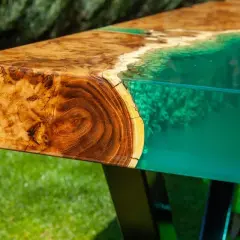 Tavolo con venature di legno e resina epossidica verde brillante, che ricorda un paesaggio marino. Attenzione: la resina epossidica è tossica.