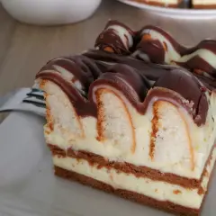 Pyszne ciasto góra lodowa z kremem i polewą czekoladową, wygląda jak deser z bajki.