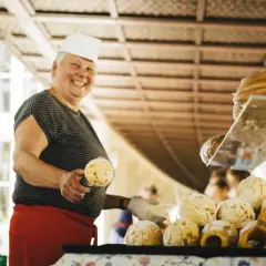 Lachende Verkäuferin mit Gebäck auf dem Bauernmarkt Bad Mergentheim.