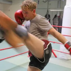 Man i thai-boxningsring i Sverige utför en spark. Träningspass med thai mora.