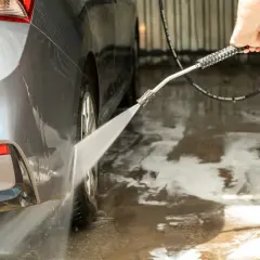 Pokazuję, jak dobrze umyć auto na myjni bezdotykowej, spłukując je wodą pod ciśnieniem.
