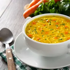 Aromaticzny rosół z makaronem, z kawałkami marchewki i natką pietruszki. Idealny na lekki posiłek, z niską zawartością kcal.