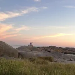 Två personer njuter av solnedgången vid Solvik camping Smögen. En idyllisk kväll vid havet.