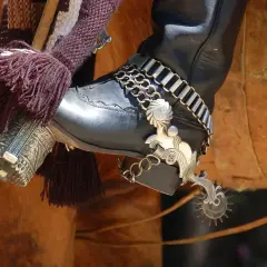 Jeździec w czarnym bucie z ozdobnymi ostrogami, gotowy do jazdy. Jak założyć ostrogi? To proste, gdy masz odpowiedni sprzęt.