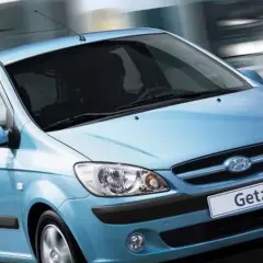 Błękitny Hyundai Getz w ruchu miejskim, z rozmytym tłem sugerującym prędkość.