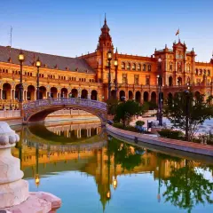 Plaza de España en Sevilla, uno de los lugares de España para visitar. Reflejos dorados en el canal y arquitectura impresionante.