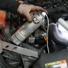 Ręka trzyma puszkę preparatu do czyszczenia DPF, sugerując rozwiązanie problemu objawów zapchanego DPF w Fordzie S-Max.