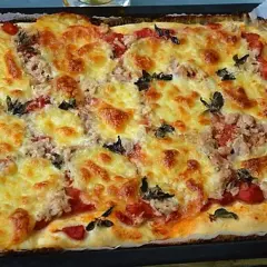 Pyszna, domowa pizza z tuńczykiem, zapieczona pod złotym serem z dodatkiem pomidorów i ziół.