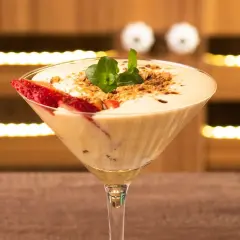 Delicioso sabayon de huevo en copa de martini, decorado con fresas y menta.
