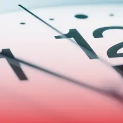Zbliżenie na tarczę zegara, wskazówki blisko godziny 12. Ile godzin pracy w styczeń 2026?