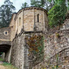 Antiguo **castillo de Chantada** con muros de piedra cubiertos de musgo y hiedra, rodeado de vegetación y árboles frondosos.