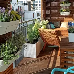 Zielony balkon w bloku, pełen kwiatów i roślin. Wygodne meble i inspiracje na stworzenie własnej oazy spokoju.