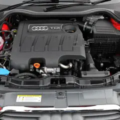Silnik 1.6 TDI Audi z widocznym zbiorniczkiem płynu chłodniczego i osłoną silnika z logo TDI.