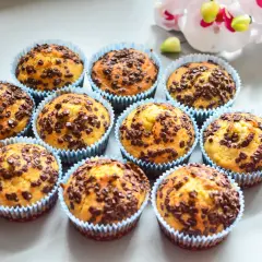Urocze muffinki bananowe z czekoladą, posypane obficie czekoladowymi drobinkami, wyglądają apetycznie.