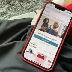 Telefon z aplikacją Vinted leży na ubraniach. Wygląda na to, że portfel Vinted nie działa, bo nie można nic sprzedać.