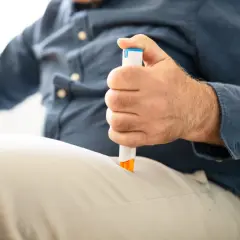 Mężczyzna używa ampułko-strzykawki z adrenaliną bez recepty, by szybko zareagować na nagły przypadek.