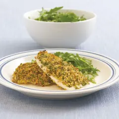Zwei Filets Fisch mit knuspriger Parmesankruste und Rucola auf einem Teller.