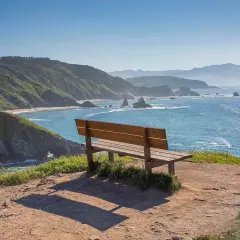 Un banco de madera invita a contemplar el mar azul y las verdes colinas. Podría ser el banco mas bonito del mundo en Vigo.
