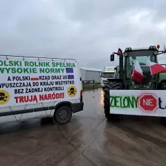 Ciężarówka i traktor z polskimi flagami i transparentami protestacyjnymi.