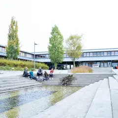 Studierende entspannen sich auf den Treppen vor der Uni Schwerin.