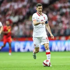 Robert Lewandowski, polska fałszywa dziewiątka, prowadzi piłkę na boisku w białej koszulce z numerem 9.
