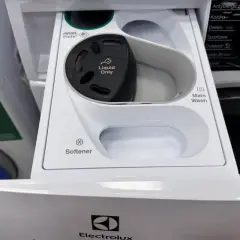 Szara przegródka na detergenty w pralce Electrolux ładowanej od góry. Widać miejsce na kapsułki Ariel, płyn do płukania i pranie główne.