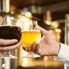 Dwie osoby wznoszą toast piwem. Zastanawiasz się, które piwo alkoholowe ma najmniej kalorii?