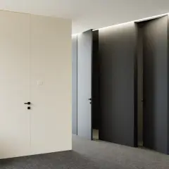 Nowoczesny korytarz z drzwiami ukrytymi w ścianie, tworzącymi efekt odwrotnej przylgi. Minimalistyczne wnętrze z subtelnym oświetleniem.
