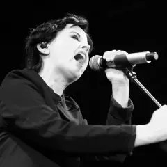 Dolores O'Riordan, jedna z członkiń The Cranberries, śpiewa do mikrofonu z pasją.