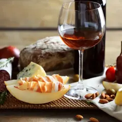 Pyszne wino z Włoch, ser, salami, pieczywo i owoce tworzą idealną przekąskę.